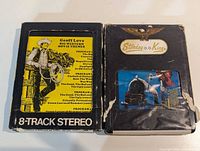 Front view of both 8-track cartridges showing labels and overall wear