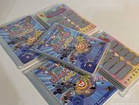 Five sealed Ty Beanie Babies Series II 1st Edition trading card packs displayed, showing front artwork