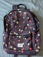 Front view showing polka dot pattern, front pocket, Fossil patch