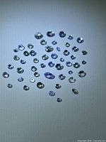 Group of loose blue-violet faceted stones on white background