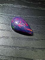 Pear cabochon Ethiopian black opal front view showing multicolor play-of-color