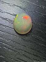 Top view of oval cabochon opal showing play of color
