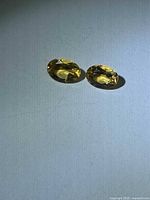 Pair of oval golden citrines on flat surface
