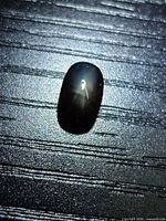 Top view showing star asterism on black star sapphire cabochon