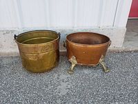 Front view of brass bucket and copper planter