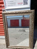 Front view of mirror leaning against storage unit, showing full frame and glass