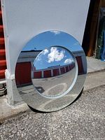Front view of round mirror showing flat center and curved reflective frame