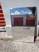 Full view of rectangular mirror leaning against wall