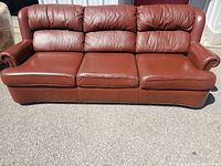 Full front view of brown leather sofa outdoors