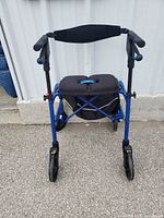 Front view of blue Nexus rollator walker showing four wheels, seat, basket, backrest, handles