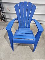Front view of blue plastic Adirondack chair showing overall design, arms and seat condition
