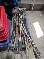 Pile of mixed hockey sticks in crate