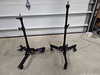 Both black wheeled light stands fully opened on floor