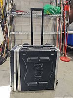 Closed black Gator rolling rack case with handle extended