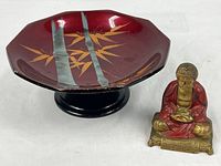 Pedestal dish and Buddha figurine side by side