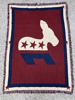 Full view of throw blanket showing donkey logo, border and fringe