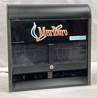 Front view of Marlboro display rack showing illuminated logo, clear shield, lock, bottom dispensing slots