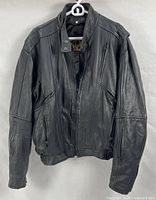 Front view of black leather motorcycle jacket on hanger