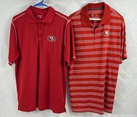 Both polo shirts front view on hangers