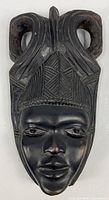 Front view of carved dark wood African mask