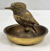 overall view of brass bird figurine on dish