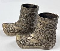 Pair of cast brass miniature boots side view showing relief decoration