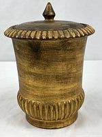 Full view of gilded cylindrical lidded urn