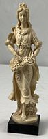 Full view of cream-colored Ruggeri figurine on black base