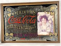 Full view of framed Coca-Cola advertising mirror showing artwork and frame