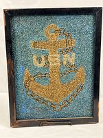 Full view of framed pebble art showing anchor, chain and USN letters
