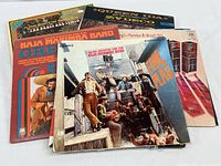 Stack of multiple LP albums showing several covers