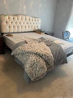 Full view of adjustable bed with tufted headboard and mattress