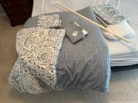 Overview of bedding, curtain panels, and rod on bed surface
