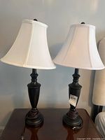 Front view of both black table lamps with white shades