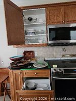 Cabinet and countertop view showing wooden bowls, tray, Wedgwood plate, glassware, white bowls