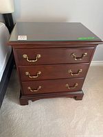 Front view showing full nightstand, drawers, pulls, base