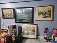 Overview showing four framed prints mounted or leaning against wall