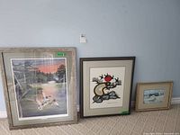 All three framed prints leaning against wall