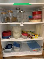 Cabinet shelves with plastic containers, tins, wraps, wire shelf