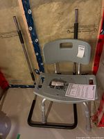Front view of assembled Guardian bath chair with legs, backrest, seat, hardware packet, and instruction manual