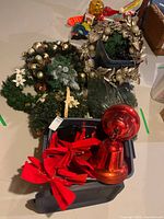 Overall lot view showing wreaths, bows, finial ornament and totes