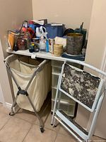 Overall view: rolling laundry hamper, step stool, plastic drawer unit, watering can, assorted supplies
