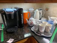 Group shot showing Keurig brewer, pod tower, teapots, pitchers, mugs on tray