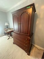 Front view of mahogany armoire showing two doors and four drawers