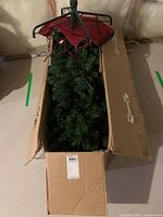 Box containing artificial tree sections with foliage visible