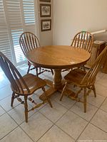 Round oak pedestal dining table with four Windsor chairs