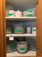 Cabinet view showing stacked plates, bowls, mugs, labeled counts