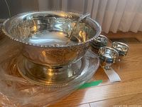 punch bowl on underplate with ladle and stacked cups