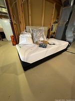 Full view of mattress on adjustable base with linens and headboard visible