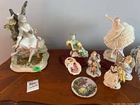Group shot of all figurines and plates on wooden surface